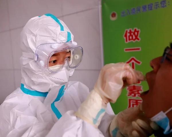 a group of people in a protective mask and gloves are working in a laboratory.
