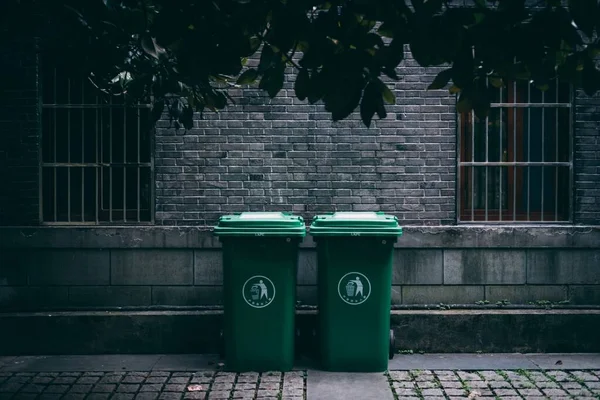 a row of green trash bin in the park