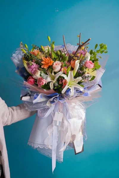 beautiful bouquet of flowers in a vase on a blue background
