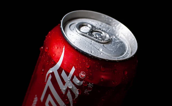 close up of a red beer can with a black background
