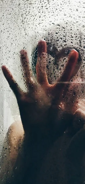 wet hand with a glass of water on a white background