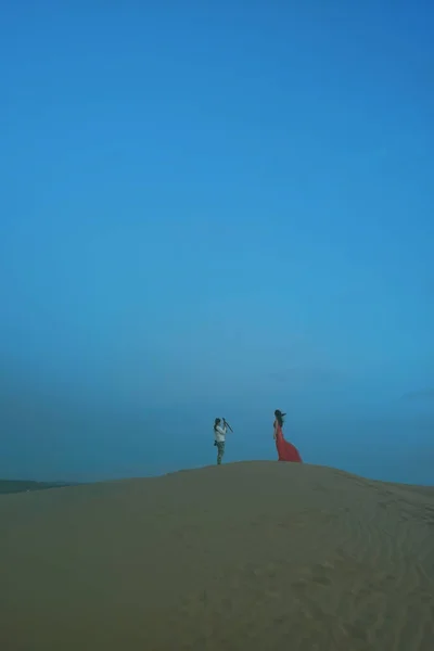 a man and woman in a desert