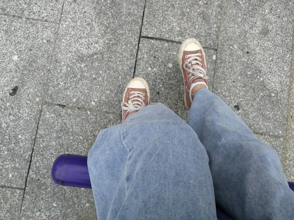 feet of a man in a sneakers on the street