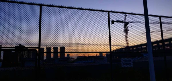 silhouette of a man in a black jacket and a white shirt on the background of the sunset