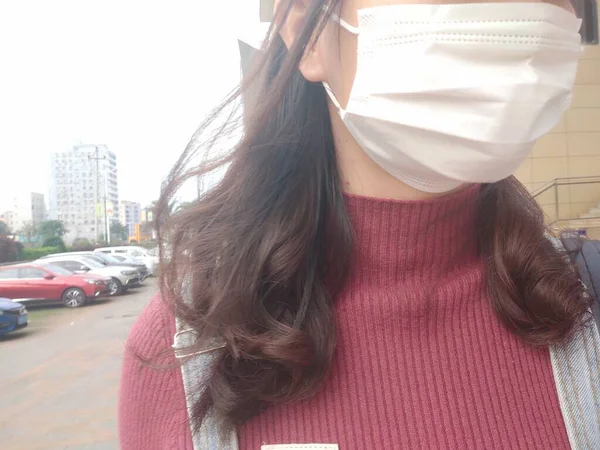 woman wearing protective mask and scarf on the street