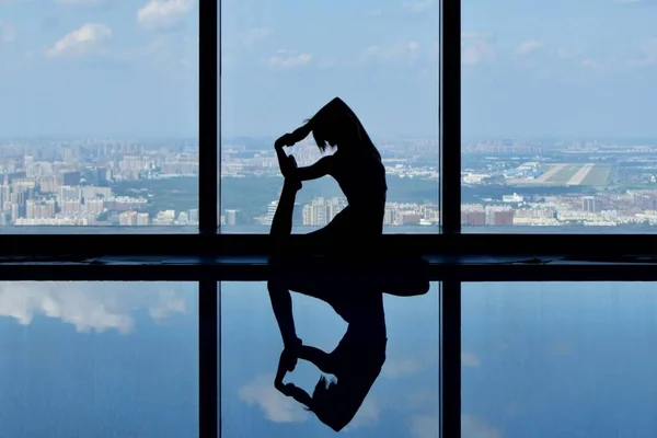 silhouette of a man in a black suit and a white shirt on the roof of the building