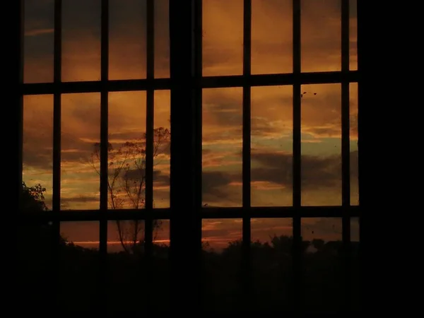 silhouette of a window with a sunset sky