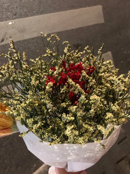 a bouquet of dried flowers in a vase on a background of a wooden table