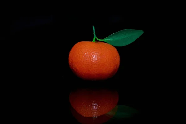 orange with drops of water on black background