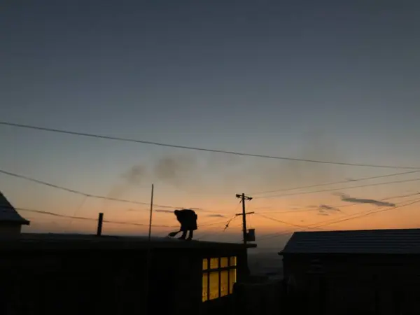 silhouette of a man and woman on the roof of the building