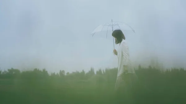 young woman in a raincoat in the rain