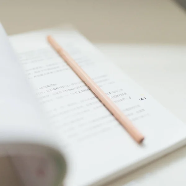 close-up of a book with a pen