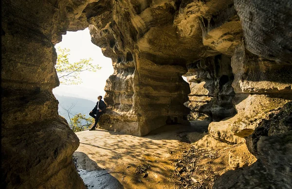 man climbing the rock in the cave