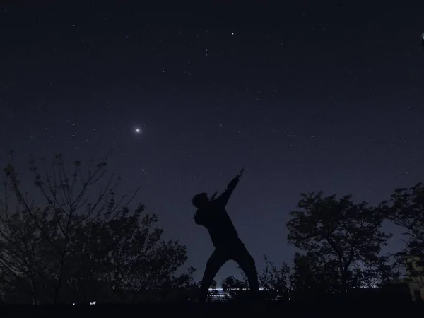 silhouette of a man in a night sky