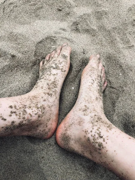 feet of a woman\'s legs on the beach