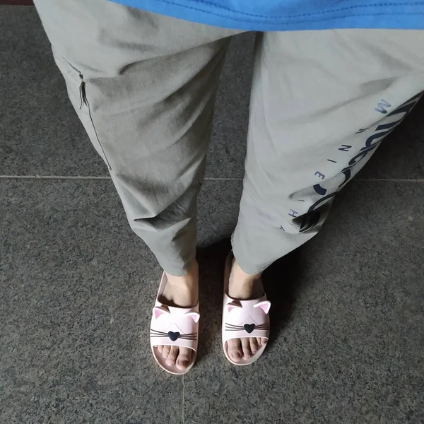 feet of a woman in a white sneakers on a street