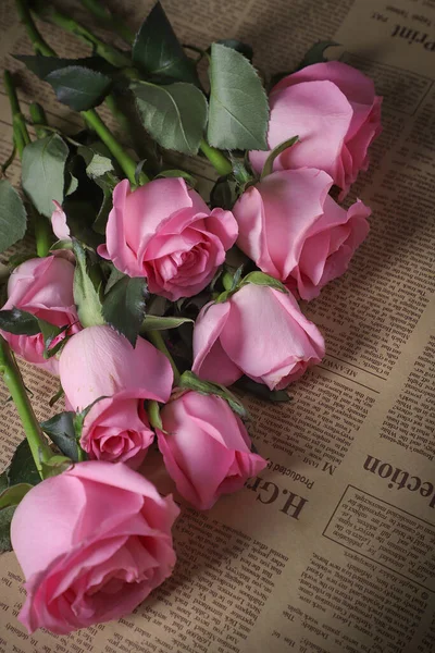 pink roses and a book on a wooden background