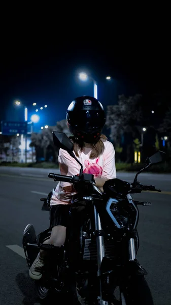 young woman with motorcycle helmet on the street