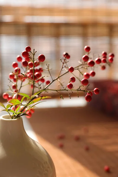 beautiful red flowers in a glass vase on a wooden table