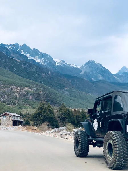 a small truck on the road in the mountains