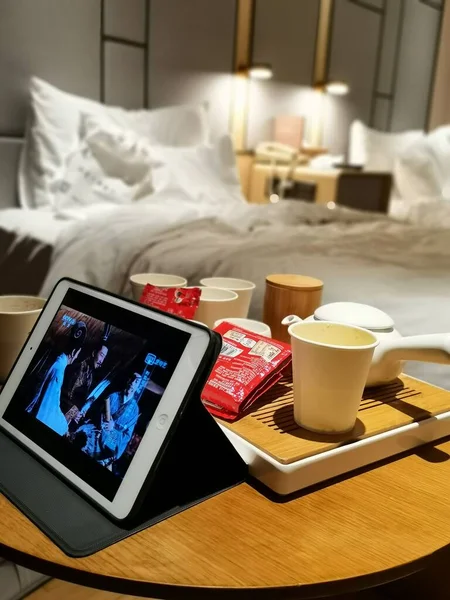 modern digital tablet with coffee cup and cookies on bed