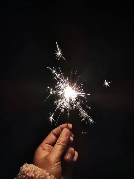 sparkler in hands on black background