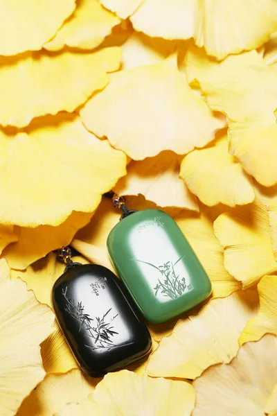 perfume bottle and leaves on wooden background