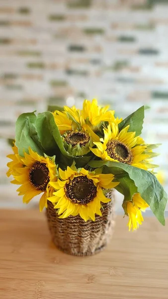 beautiful bouquet of sunflowers in a vase on a wooden background