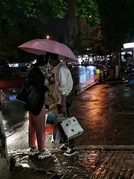 man in a rain coat with a umbrella in the city