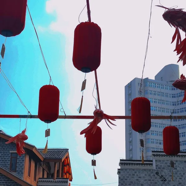 red and white lanterns hanging on the roof of the city