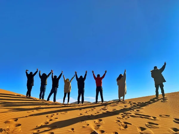 group of people walking in the desert