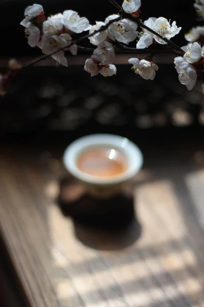 beautiful white flowers and a cup of tea on a wooden table