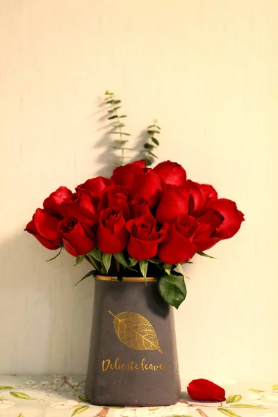 red roses and a book on a wooden background