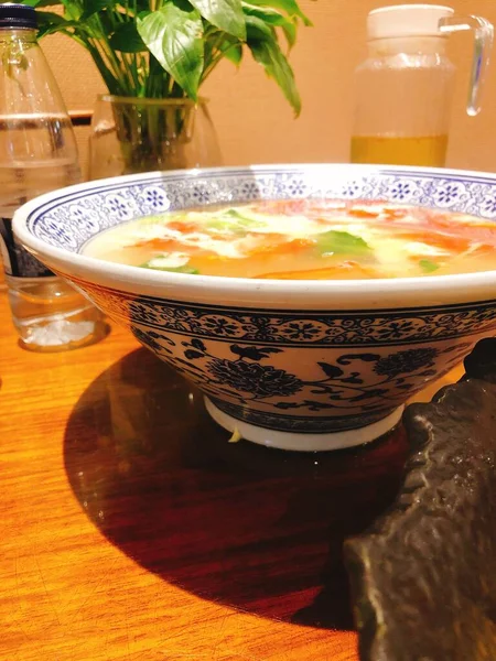 a cuisine photo of a soup with a cup of meat