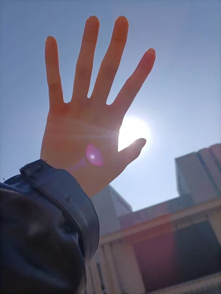 female hand with a stop sign on the beach