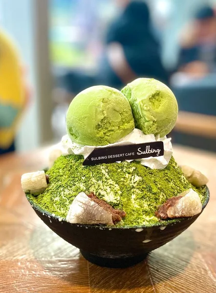 green ice cream in a bowl on a wooden table