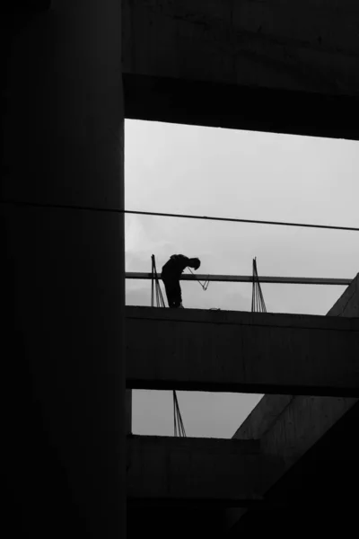 silhouette of a man and woman in a black suit and a white shirt on the roof of the building