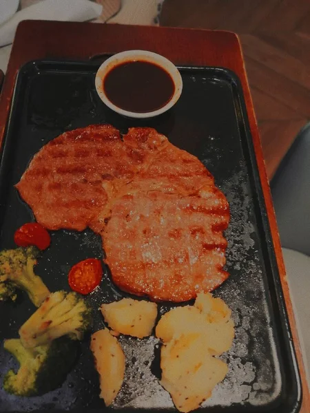 fried pork steak with sauce and tomato