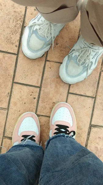 feet of a man and woman shoes