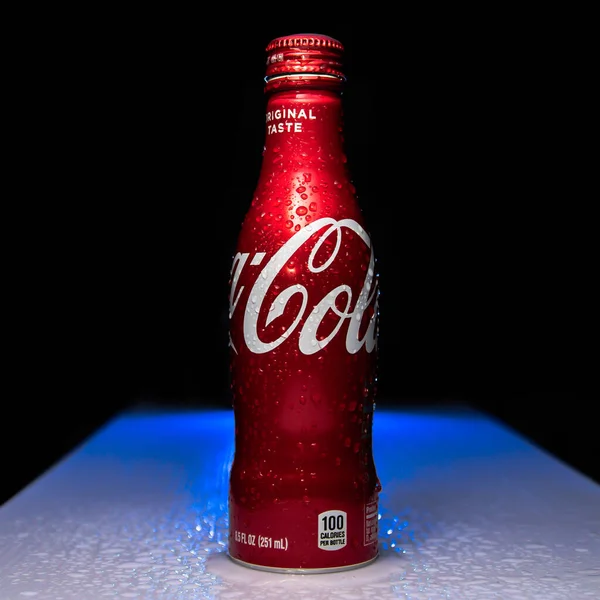 red bottle with a glass of water on a black background