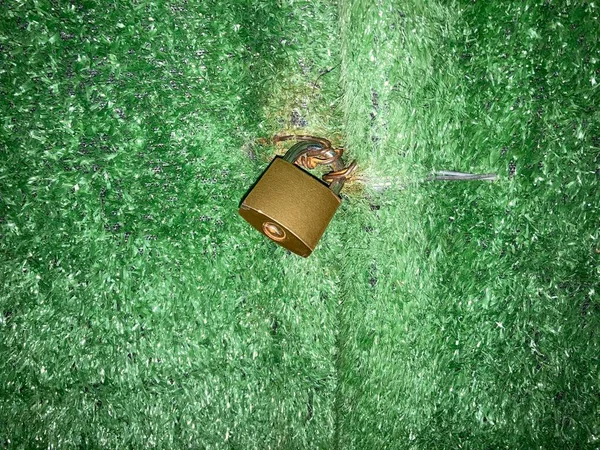 green metal lock on a wooden background