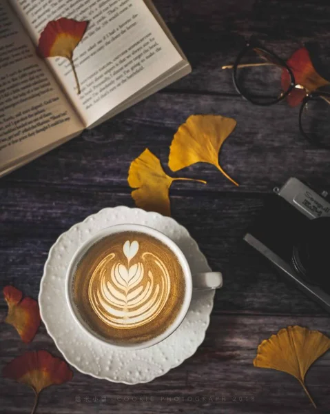 cup of coffee and a book on a wooden background