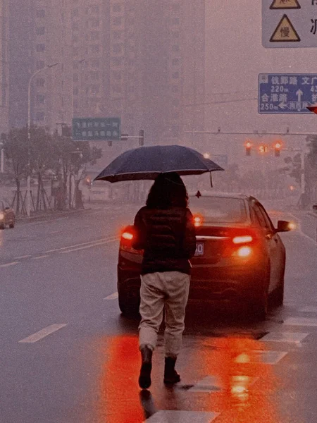 a man in a raincoat walking in the city