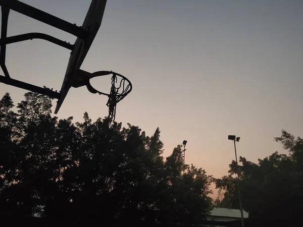 silhouette of a basketball hoop on the street