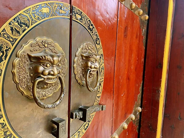 golden door knocker on the wooden gate