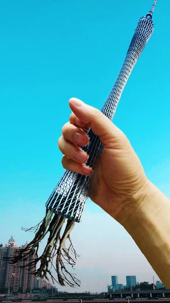 hand holding a guitar on a blue sky background