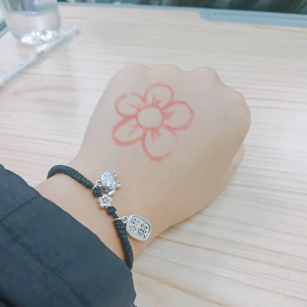 female hands with a tattoo on the table