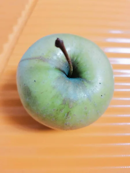 close up of a green apple on a white background