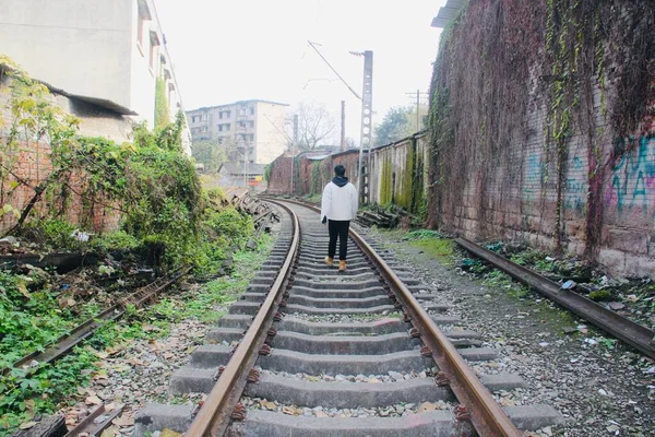 a man in a suit with a backpack on the railway tracks