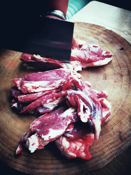 raw beef meat with knife and fork on a black background